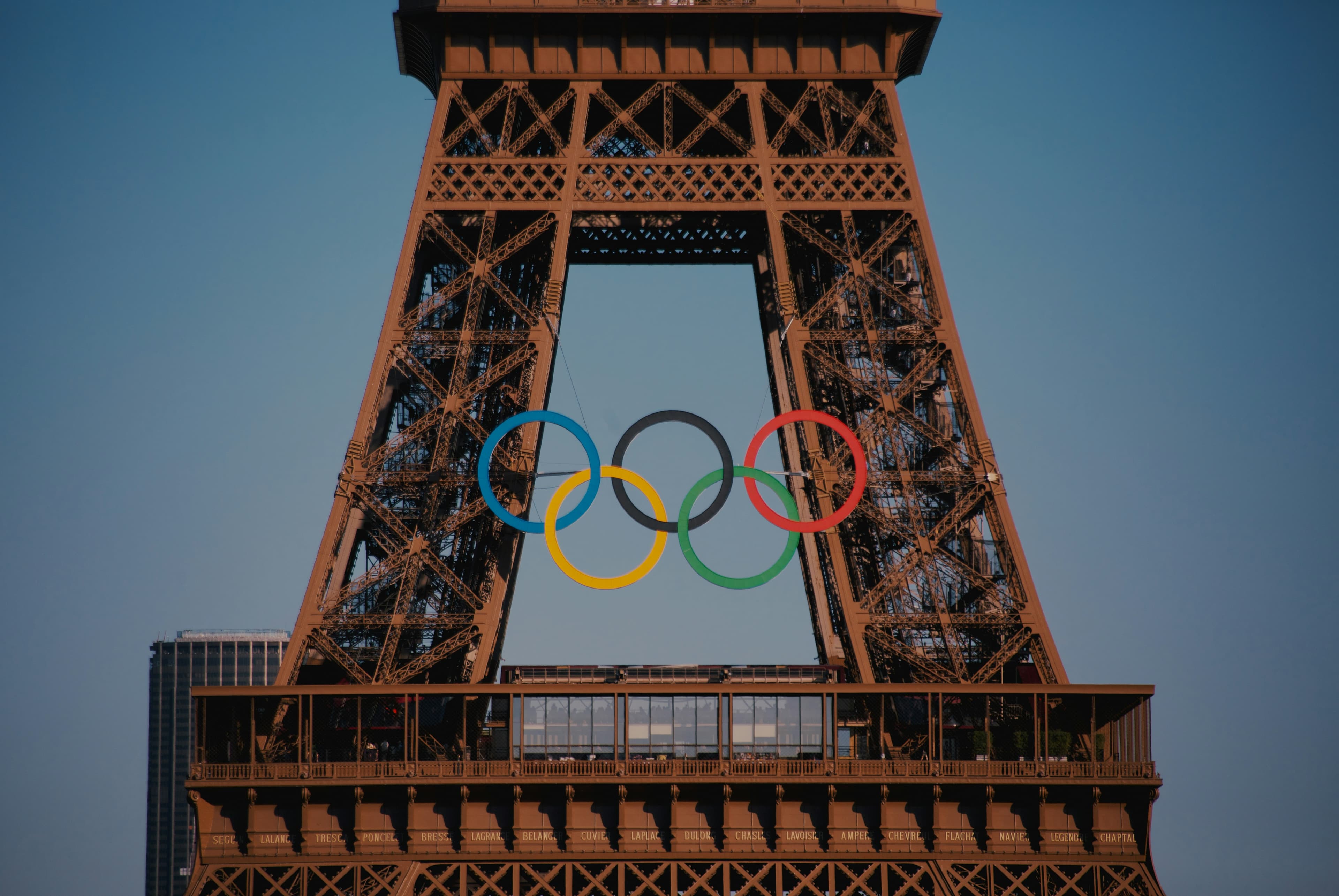 The Olympic rings are displayed on the Eiffel Tower, symbolizing the upcoming Paris 2024 Olympic Games, with parts of a cityscape in the background—an iconic sight before global events like Vikings vs Steelers 2025 capture the world's attention.